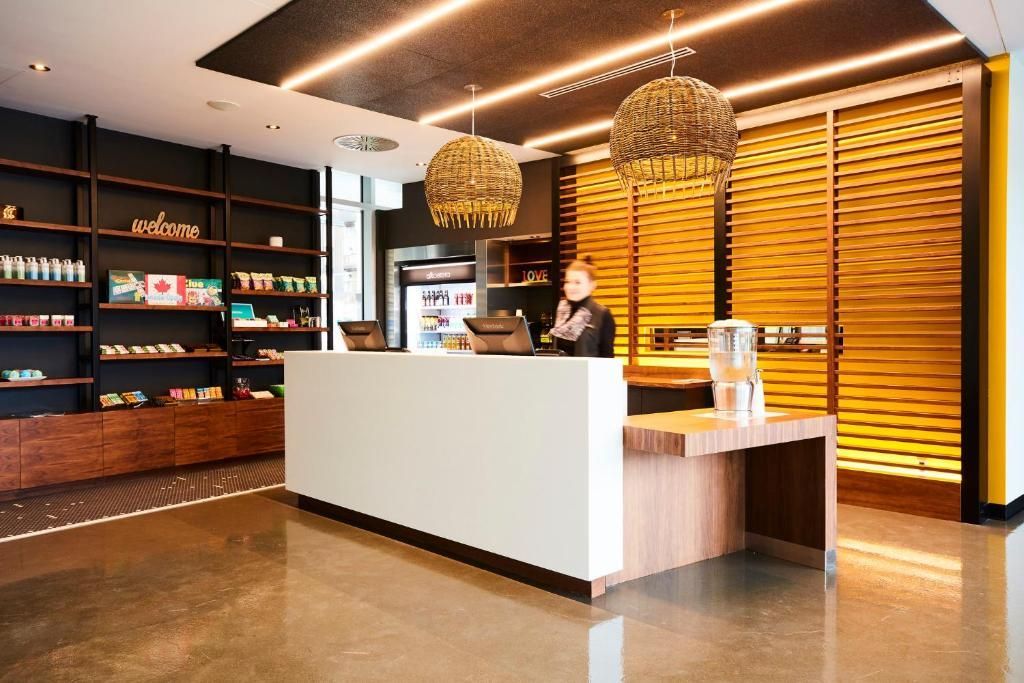 Modern café-interieur met een witte toonbank, warme houten planken en twee hangende pendellampen.