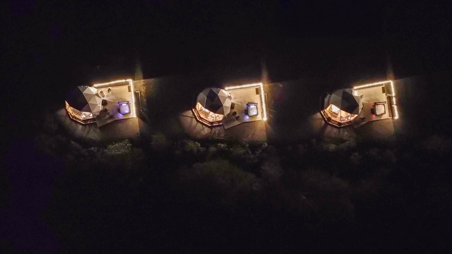 Drie verlichte domes van Appalaches Domes in de nacht, van bovenaf gezien.