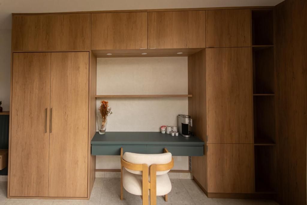 Een studeerhoek met houten lambrisering, een ingebouwd bureau, stoel, planken en een kleine lamp.