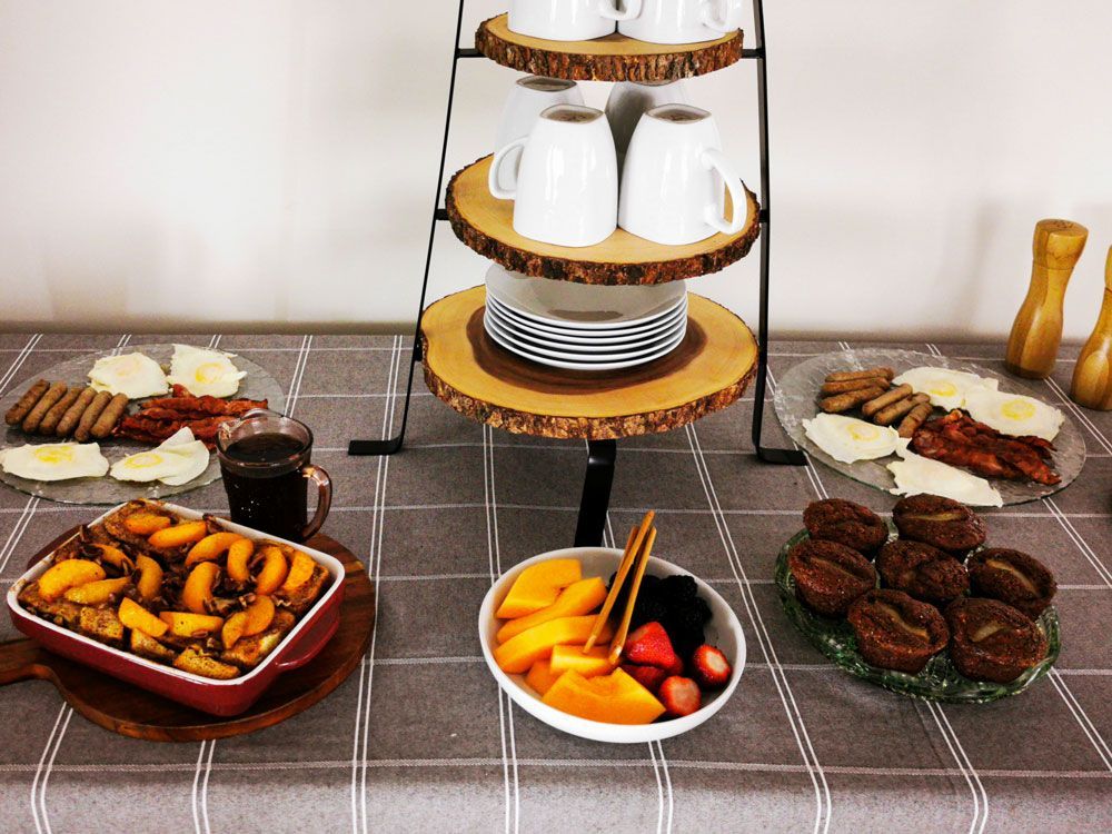 Een buffettafel met desserts, fruit, gebak, koffie en hartige gerechten, opgediend op een betegelde ondergrond.