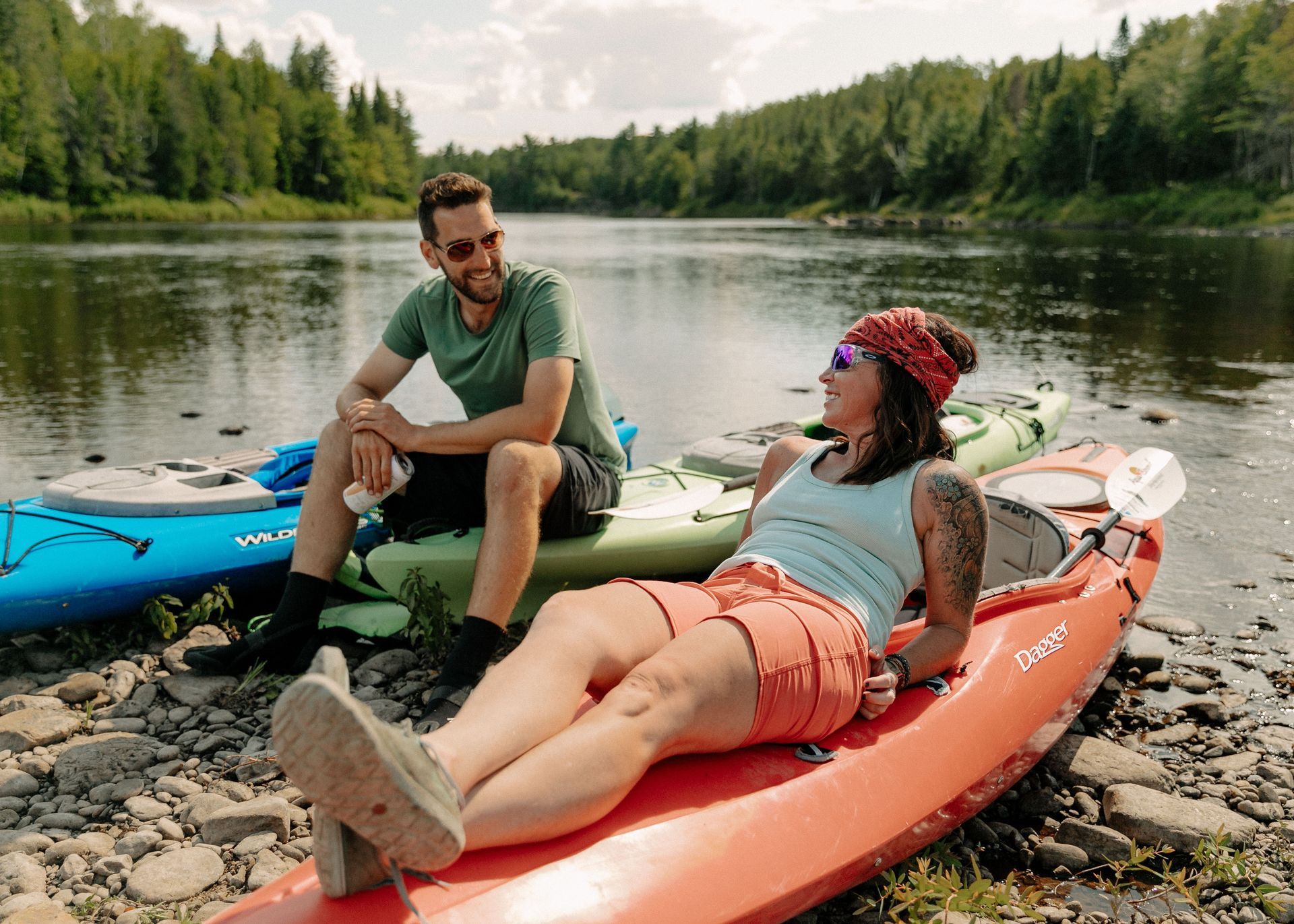 @Handcraft Courtesy of Travel Manitoba Een stel maakt een selfie voor een camper. Ze glimlachen in een bosrijk gebied.