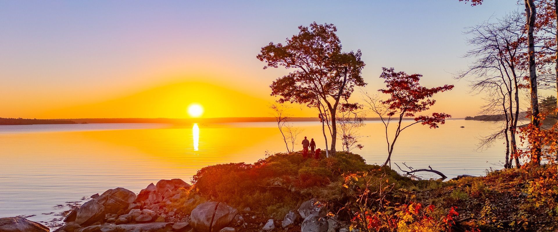 Prachtige rivier in Canada Een snelstromende, turquoise rivier kronkelt door een rotsachtig landschap, met bergen en altijdgroene bomen op de achtergrond.