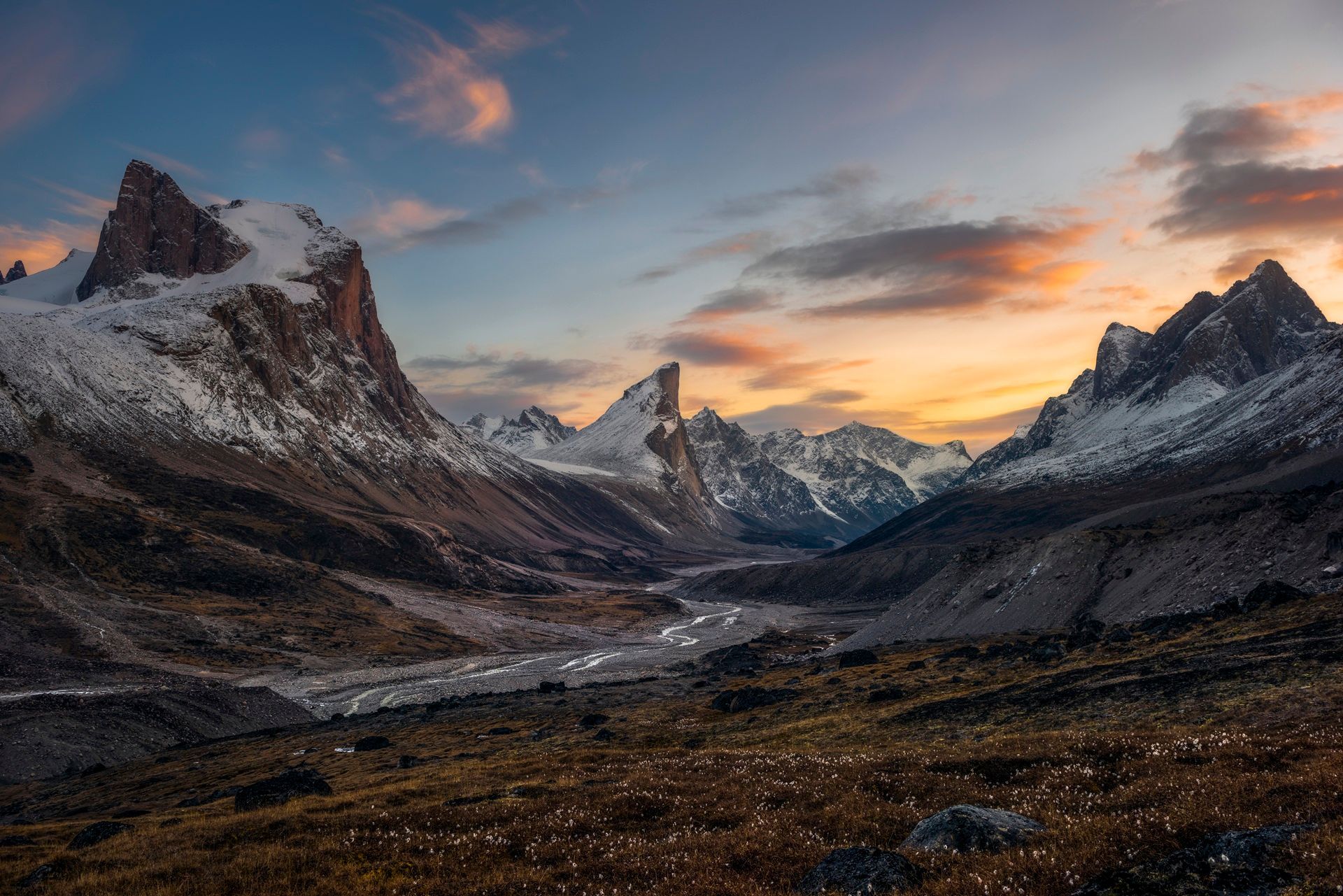 @ Artur Stanisz Snow-capped mountains at sunset with a valley and golden sky.