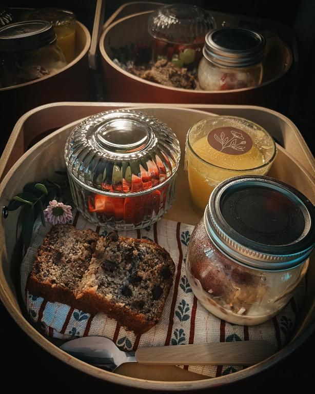 Assortiment afhaalmaaltijden in bakjes en potjes, inclusief rijst, gebak en sauzen in een schaal.