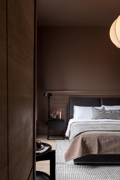 Gezellige slaapkamer met een bed, nachtkastje, warme verlichting en een houten kledingkast.