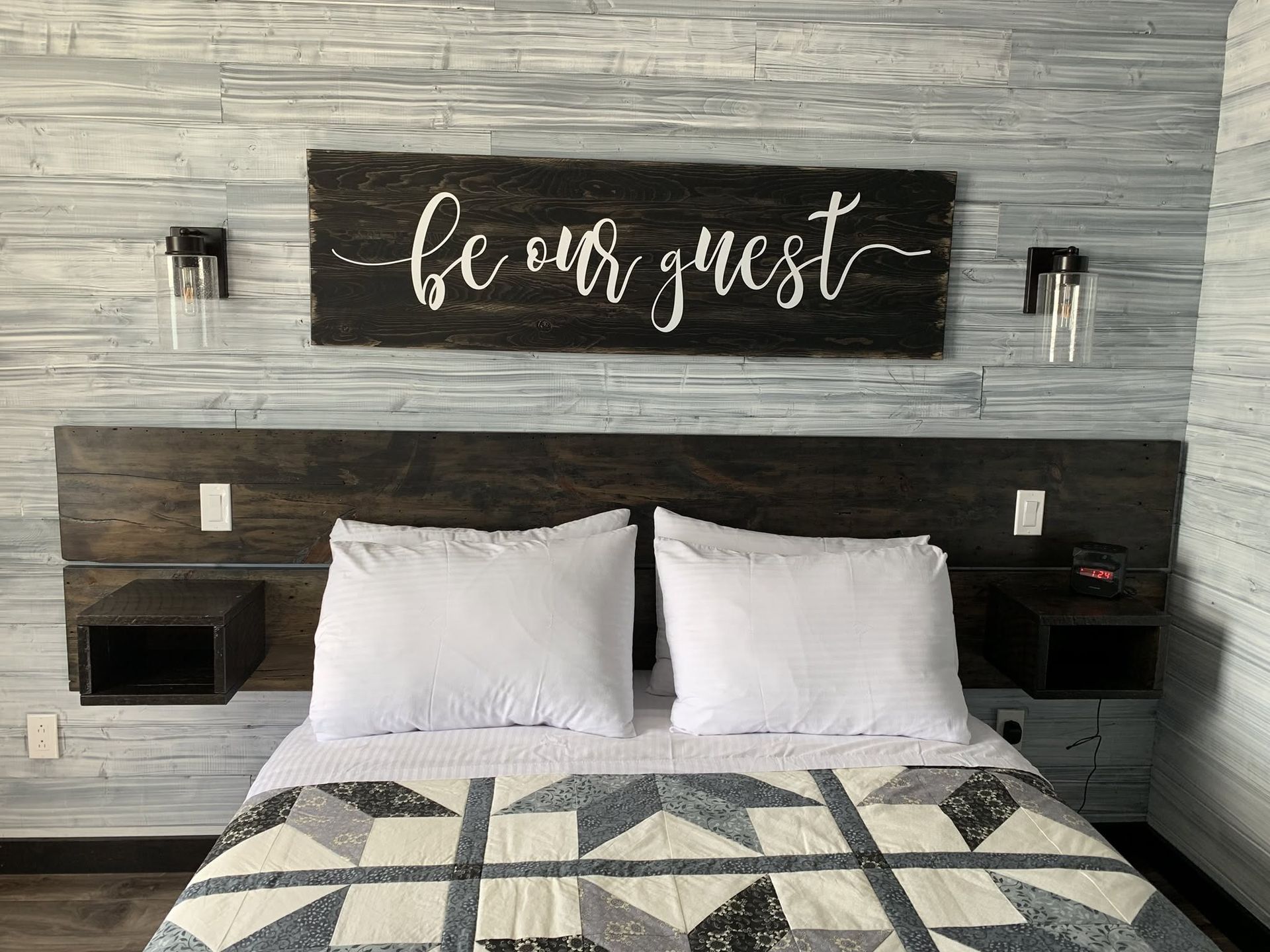 Gastenslaapkamer met wit beddengoed, houten hoofdbord en een