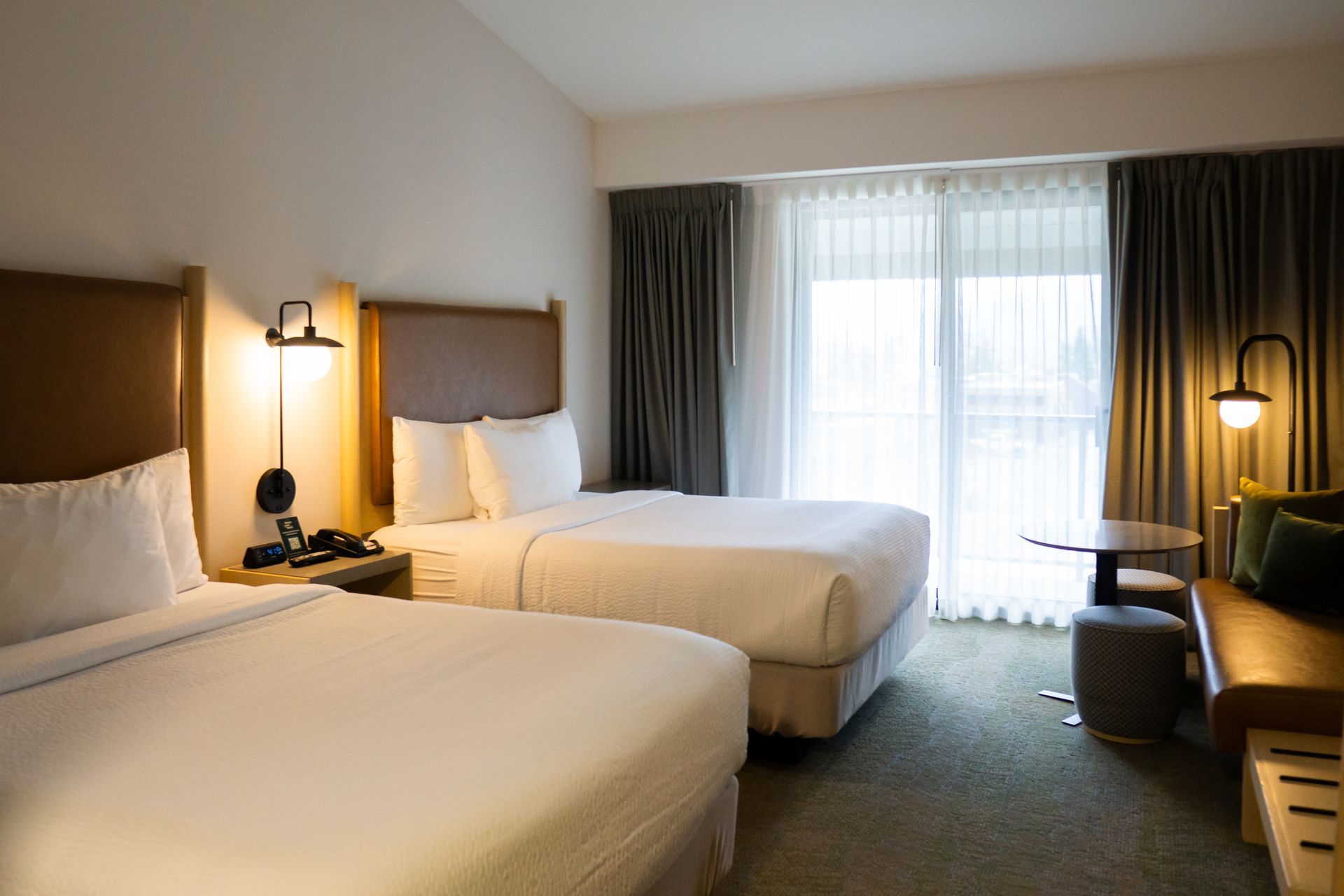 Hotelkamer van Forest Park Hotel Jasper met twee witte bedden, nachtlampjes en een raam met gordijnen.