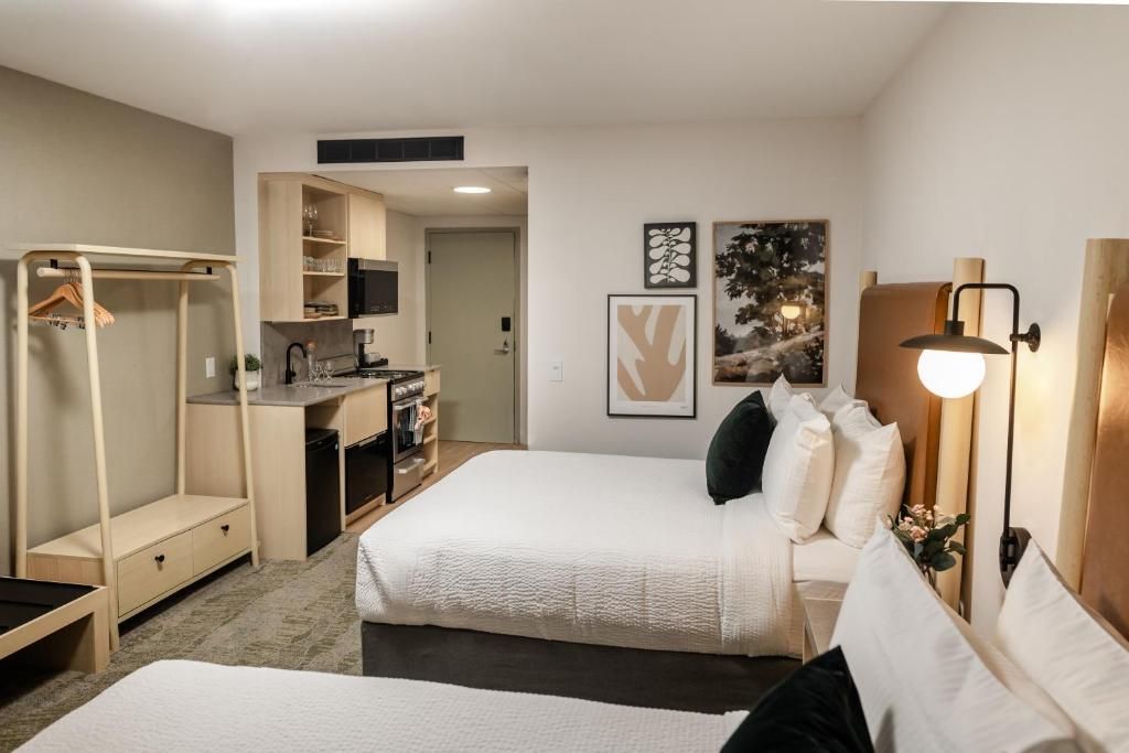 Studio-appartement slaapkamer bij Forest Park Hotel, Jasper met twee bedden, kitchenette, kledingrek en ingelijste wanddecoratie