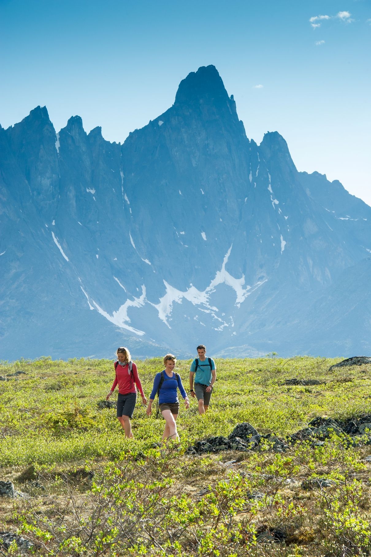 Tombstone National Park © Government of Yukon Drie wandelaars door Tombstone National Park, Yukon, met grillige bergtoppen op de achtergrond.