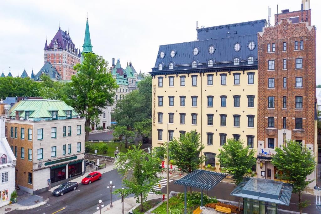 Stadsstraat met historische gebouwen, bomen en een geparkeerde rode auto onder een bewolkte hemel.