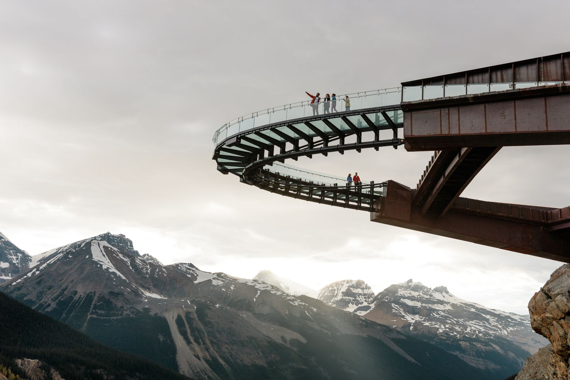 De Skywalk aan de Icefields Parkway met uitzicht over een bergdal en besneeuwde bergtoppen op de achtergrond.