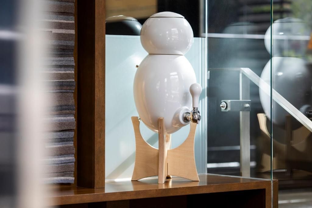 Witte robotfiguur op een plank in een glazen vitrine.