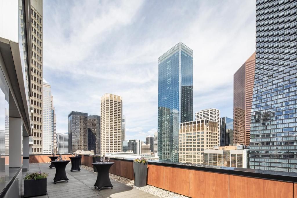 Dakterras met tafels en stoelen met uitzicht op moderne glazen wolkenkrabbers in de skyline van de stad.
