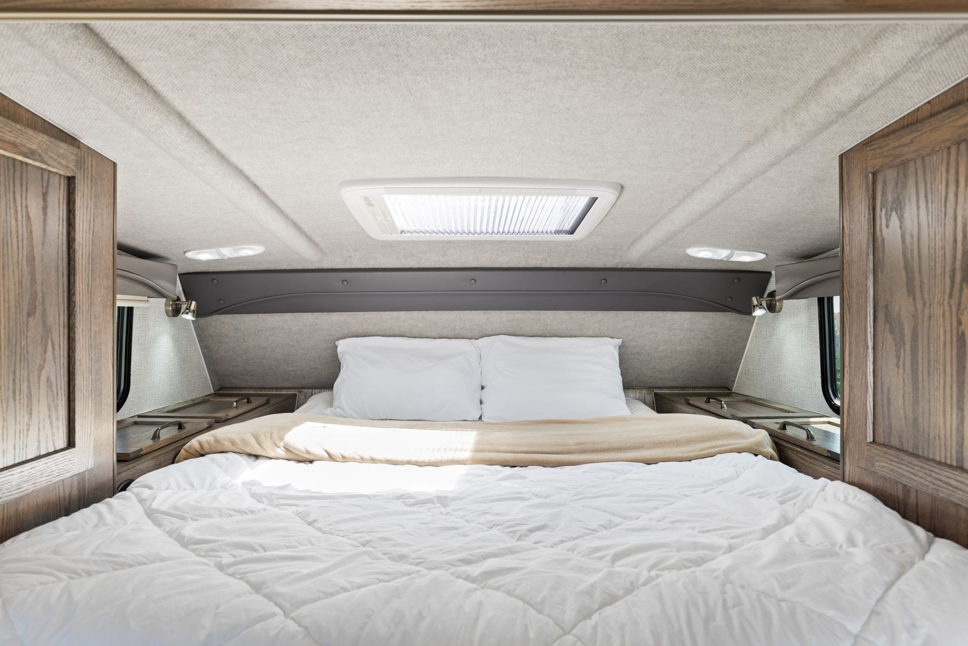Knusse slaapkamer in een Maxi Travel 4x4 Camper met een queensize bed