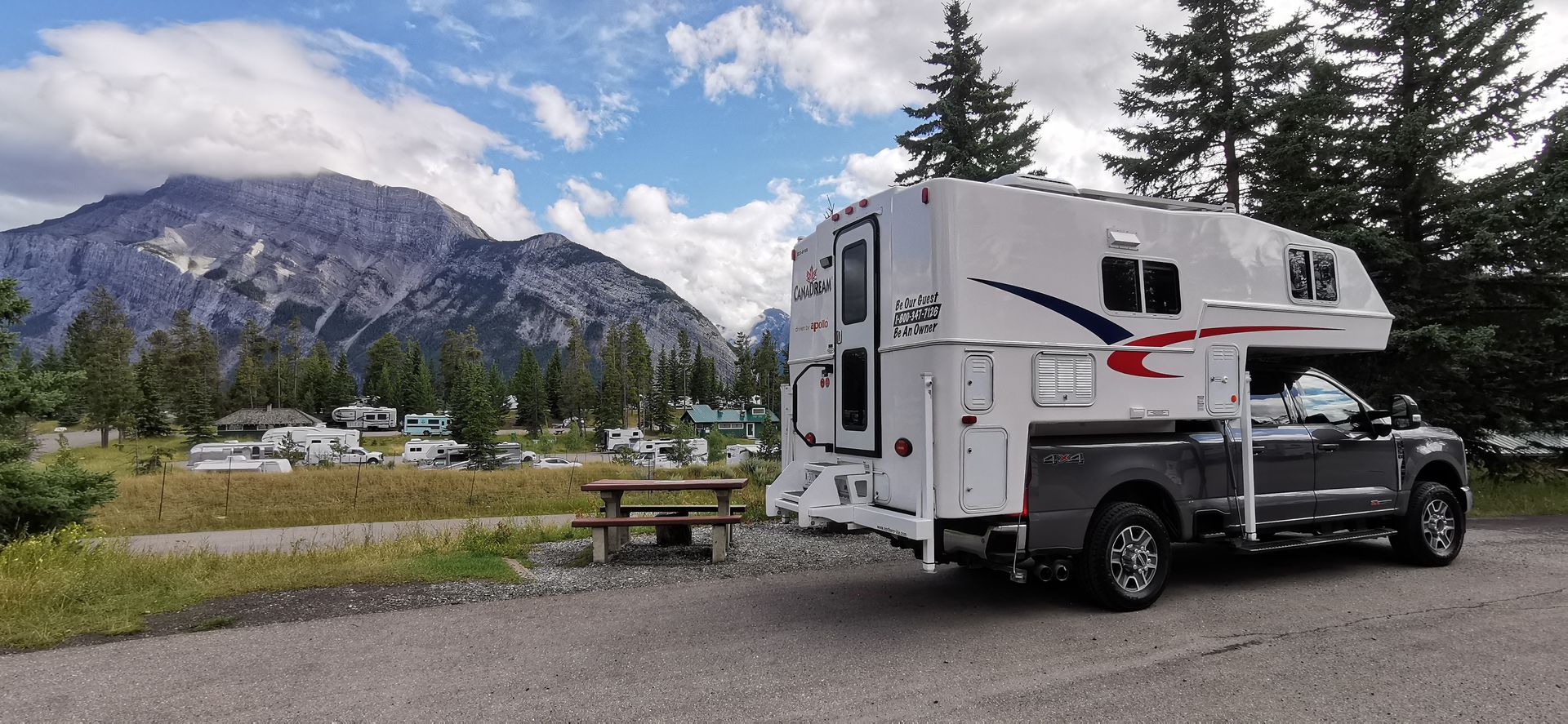 Maxi Travel 4x4 Camper geparkeerd bij de bergen onder een bewolkte hemel