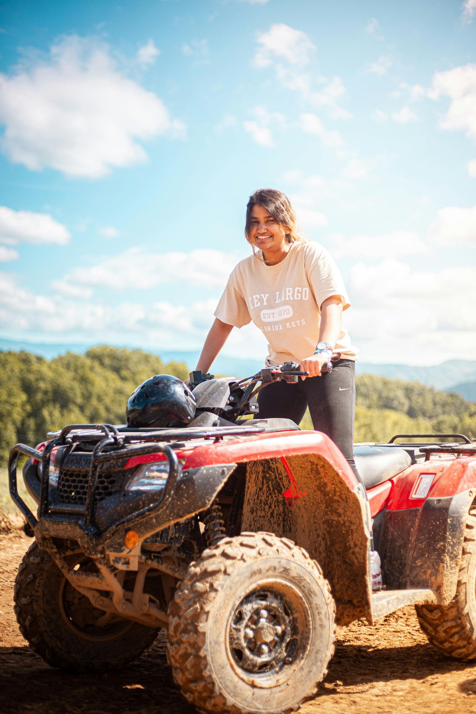 @Handcraft Courtesy of Travel Manitoba Persoon op een rode quad in een modderig veld onder een helderblauwe hemel.
