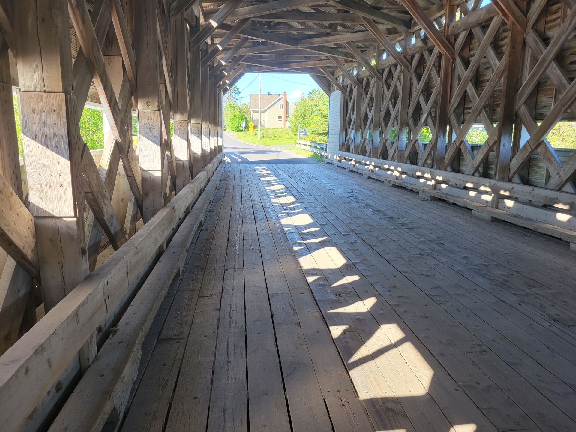 Interieurbeeld van een Covered Bridge in Amqui, Quebec Canada, waar zonlicht op de vloer valt.