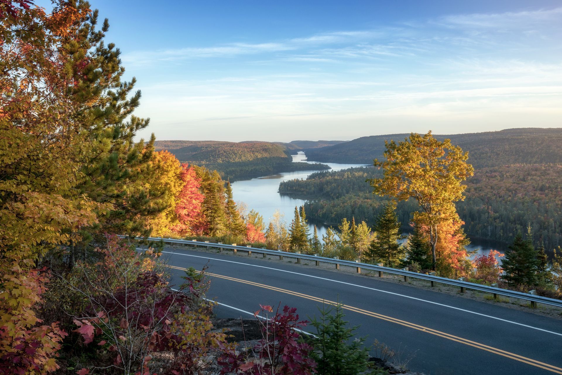 Schilderachtig uitzichtpunt in Mauricie, Canada, in de herfst met een kronkelende rivier, kleurrijke bomen en een weg op de voorgrond.