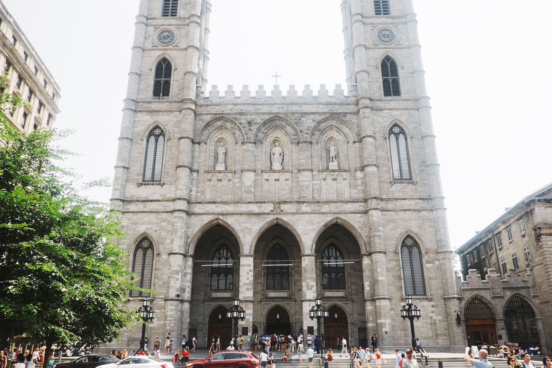 Basilique Notre-Dame de Montréal met dubbele torens en boogvormige ingang, gezien vanaf een drukke straat beneden