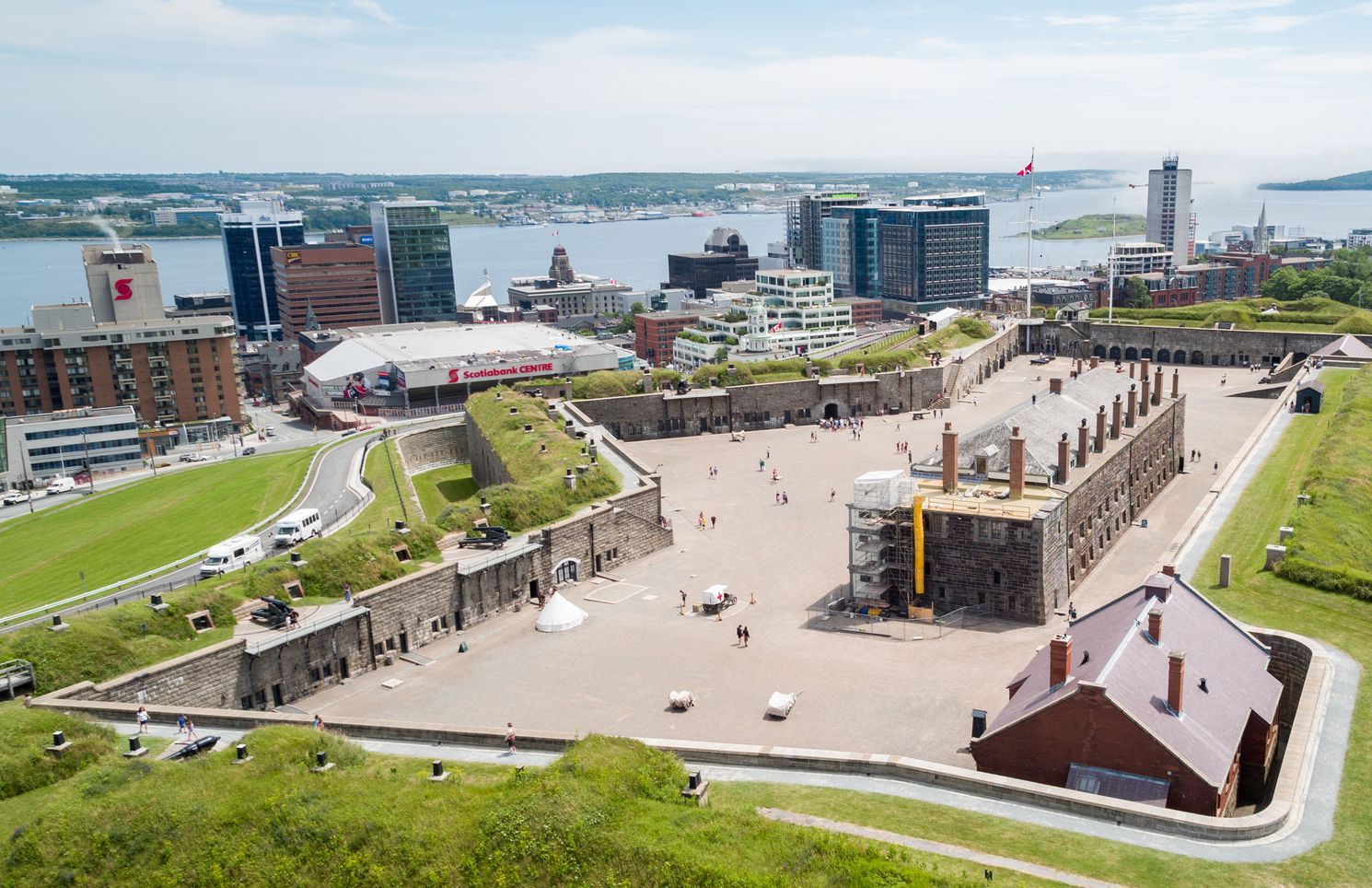 Luchtfoto van de citadel van Halifax op Nova Scotia, Canada, met groene heuvels, ruïnes van een historisch fort en stadsgebouwen aan de overkant van de haven.