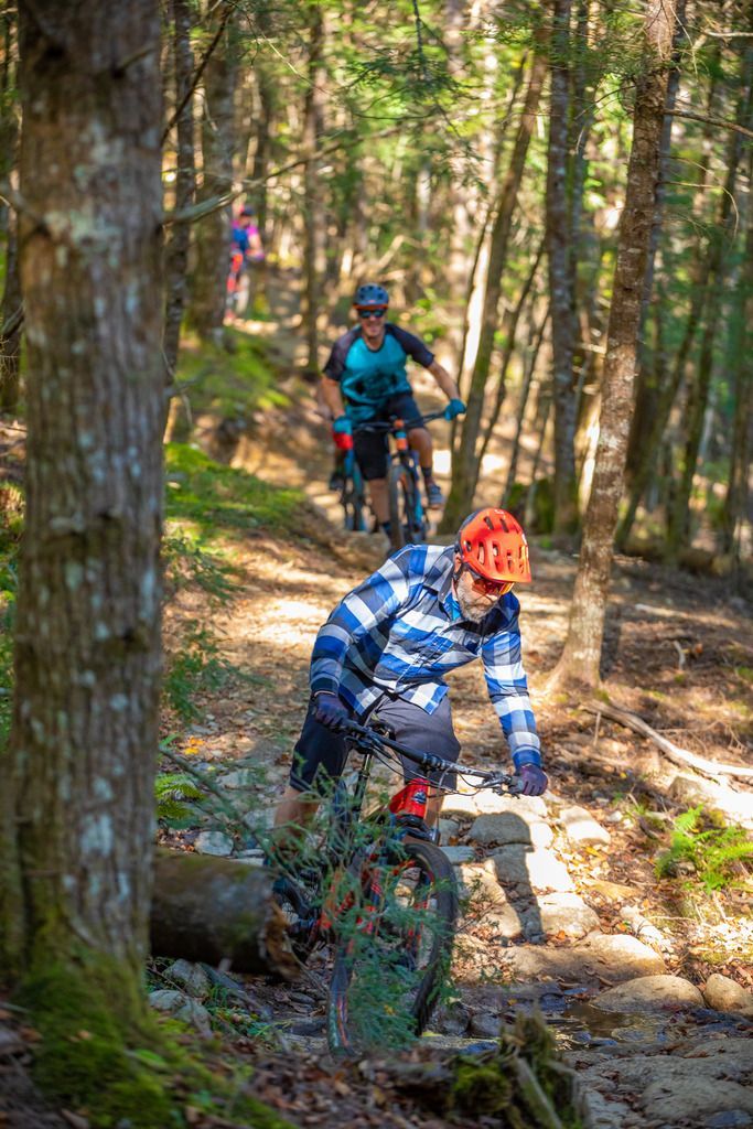 Twee mountainbikers rijden over een smal bospad in het Kejimkujik National Park, Nova Scotia.