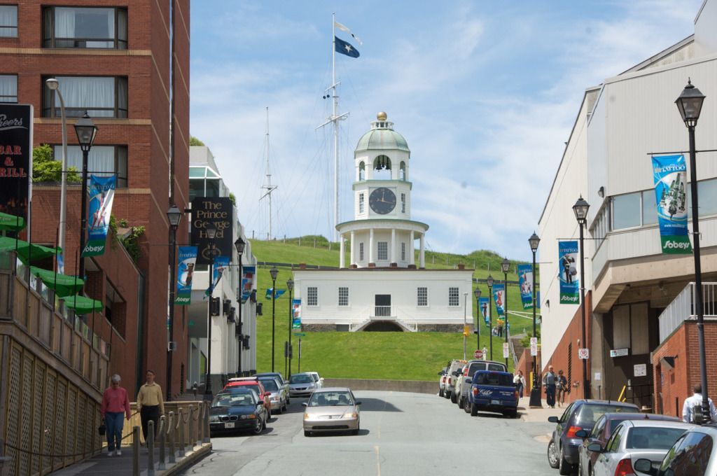 Straat die leidt naar de witte Town Clock in de citadel van Halifax op Nova Scotia, Canada,, met geparkeerde auto's en bakstenen gebouwen aan weerszijden.
