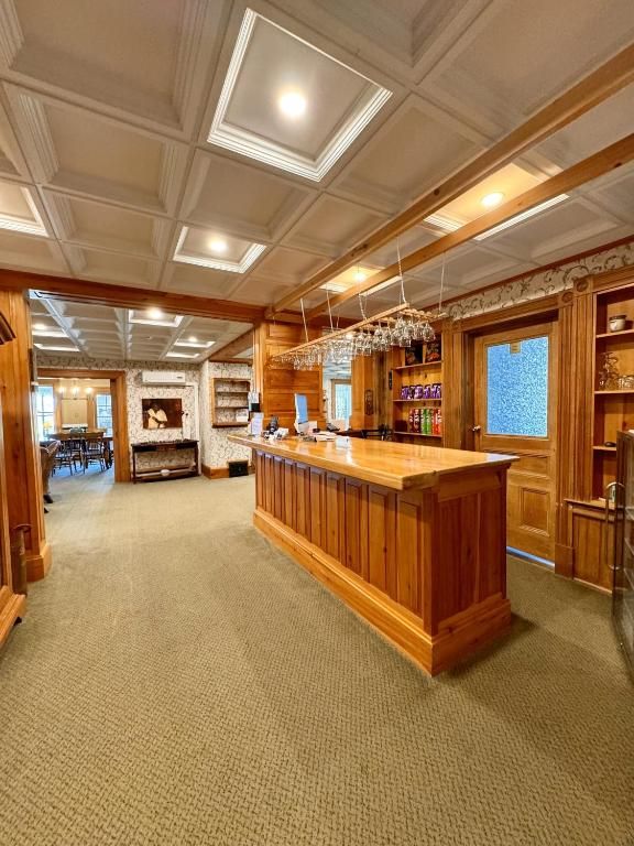 Een lobby met houten lambrisering, een centrale receptiebalie, beige vloerbedekking en warme plafondverlichting.