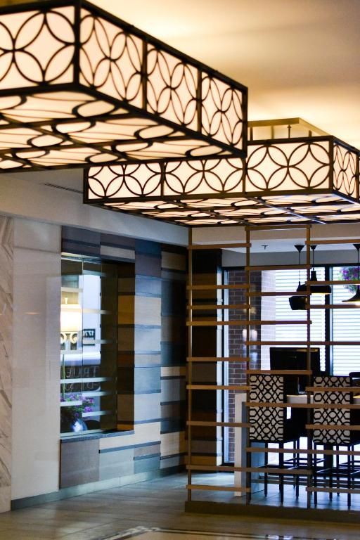 Modern restaurantinterieur van The Prince George Hotel, Halifax met decoratieve plafondlampen en wandpanelen met patronen.