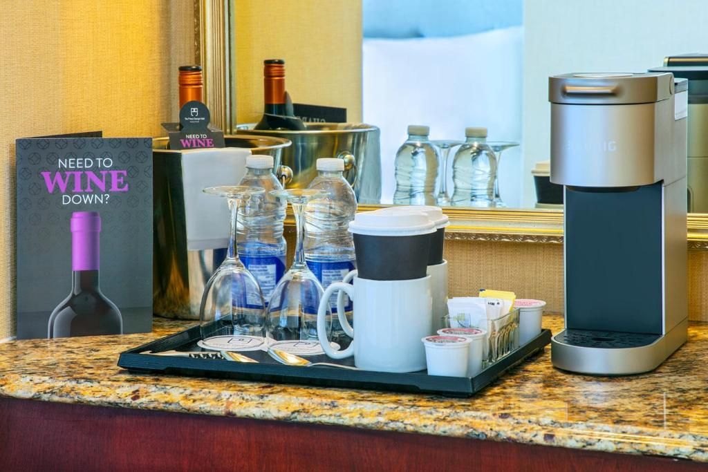 Zelfbedieningswijnstation van The Prince George Hotel, Halifax met flessen, glazen en een dispenser op een aanrecht.