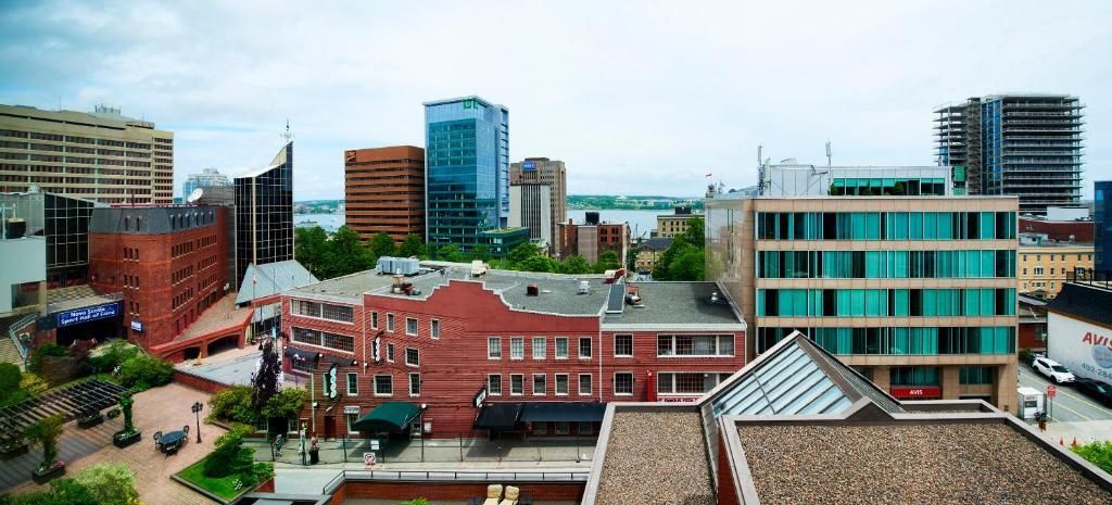 Stadsgezicht vanuit The Prince George Hotel, Halifax met een mix van rode bakstenen en moderne glazen gebouwen onder een bewolkte hemel.