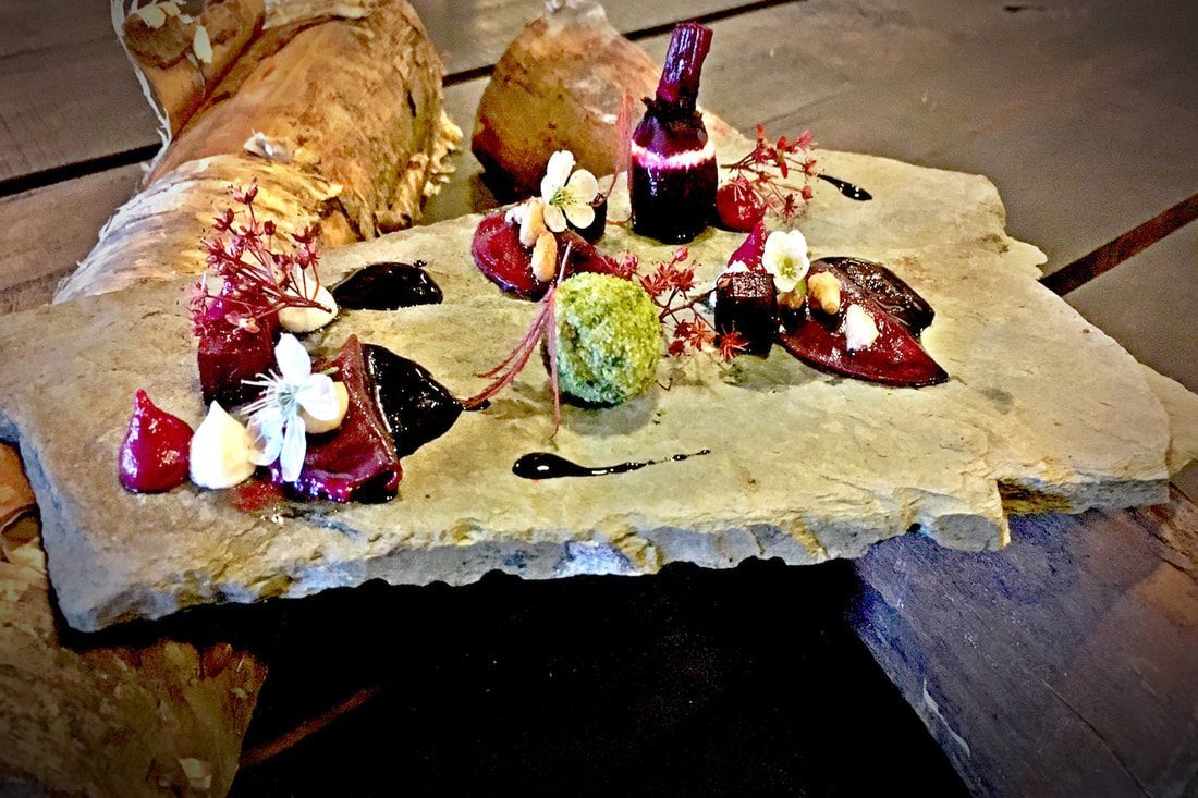 Chocoladedesserts op een rustieke schaal met aardbeien, slagroom en een klein flesje op tafel.