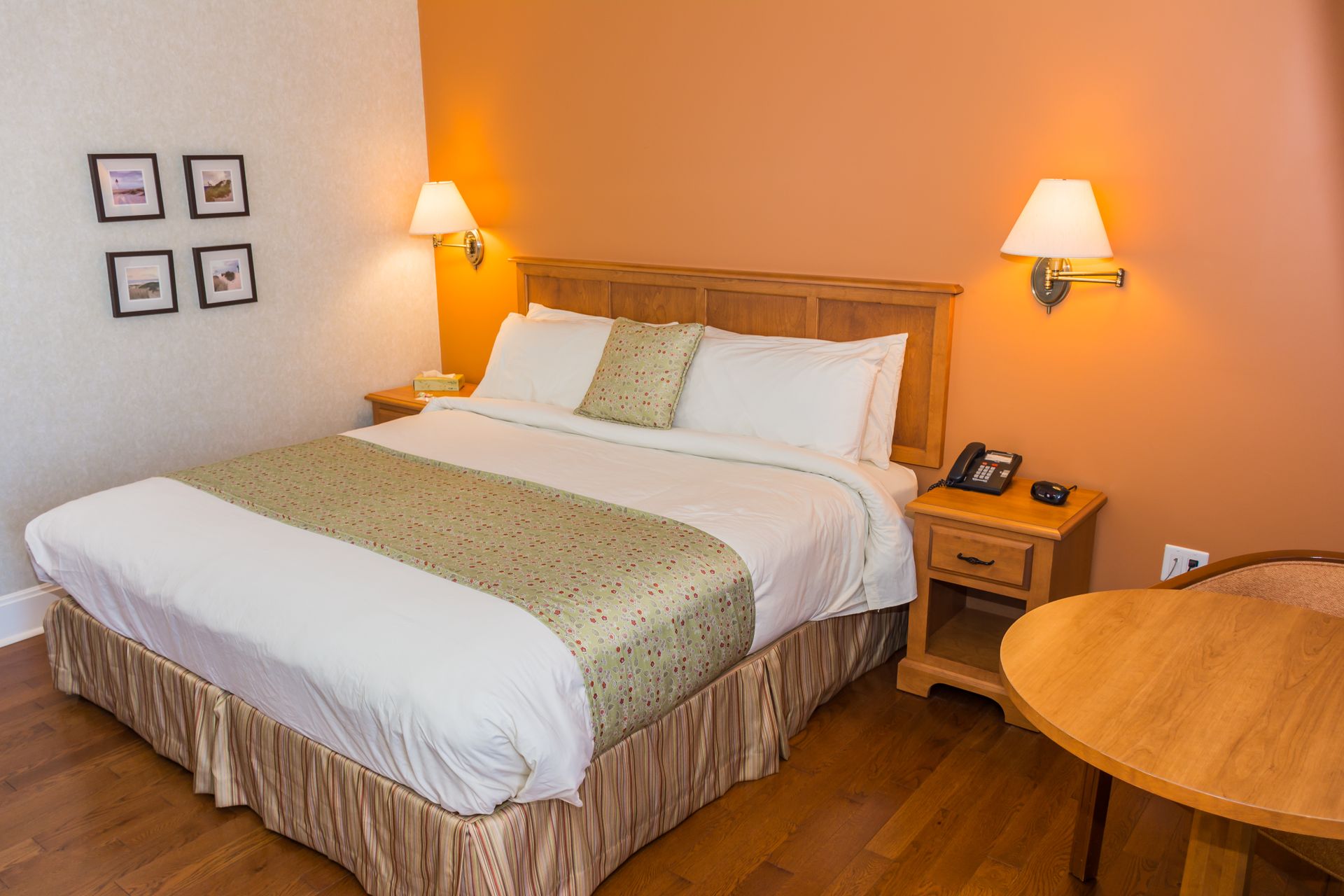 Gezellige slaapkamer met een netjes opgemaakt bed, nachtlampjes en warme houten meubels.