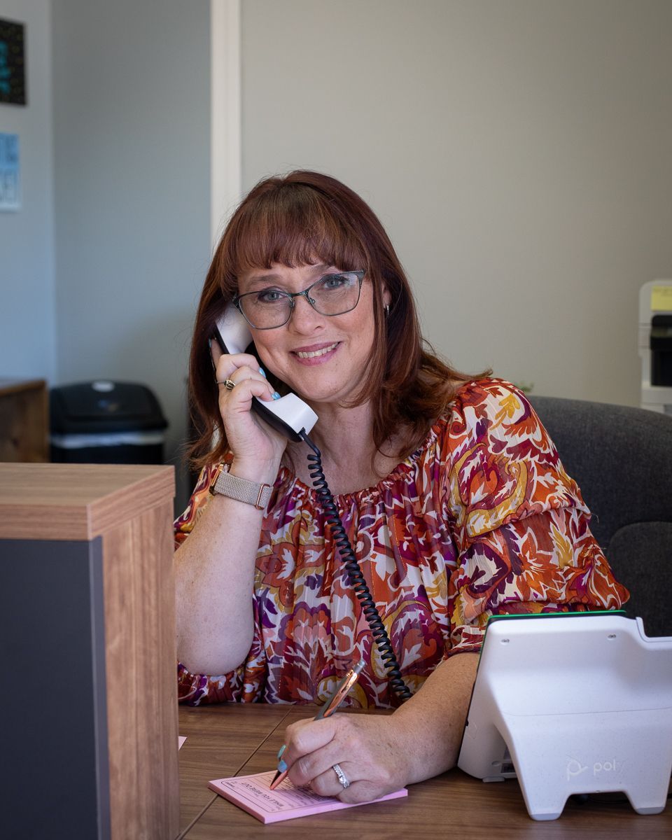 Smiling woman in a patterned dress standing in a bright office