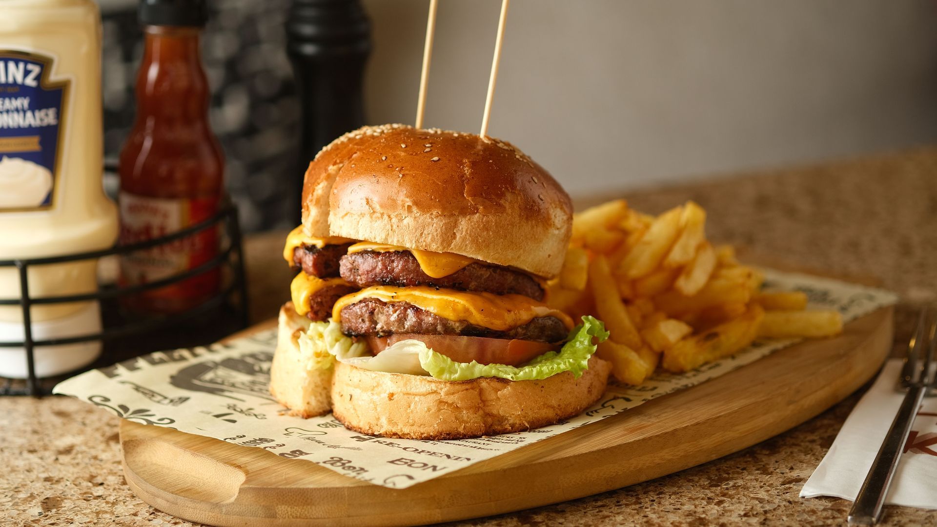 Burger with fries on a wooden board in a casual diner setting