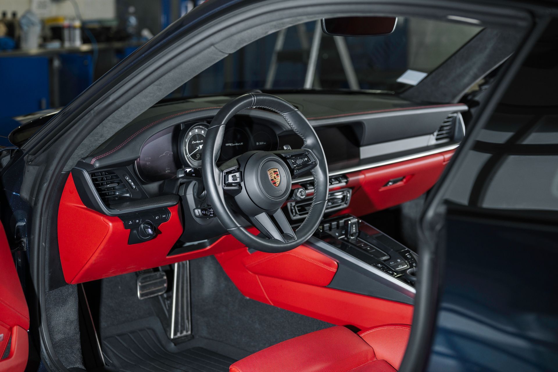 The interior of a porsche 911 turbo s with red seats and a steering wheel.