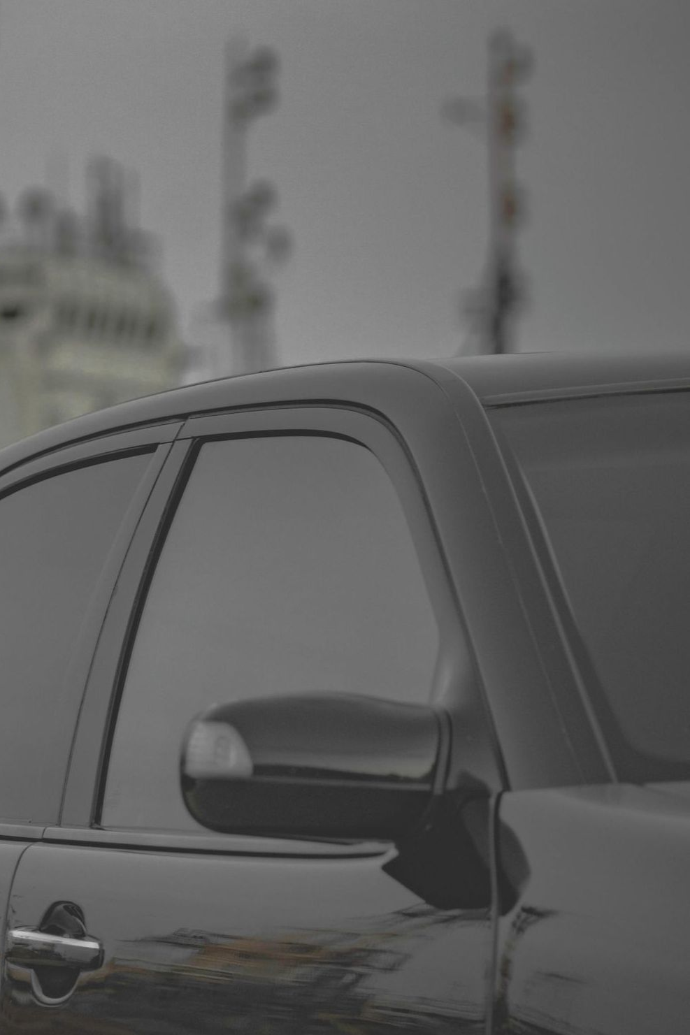 A person is installing a window tint on a car.