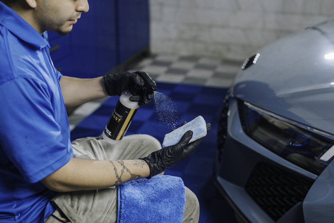 A man is wrapping a car with plastic wrap.
