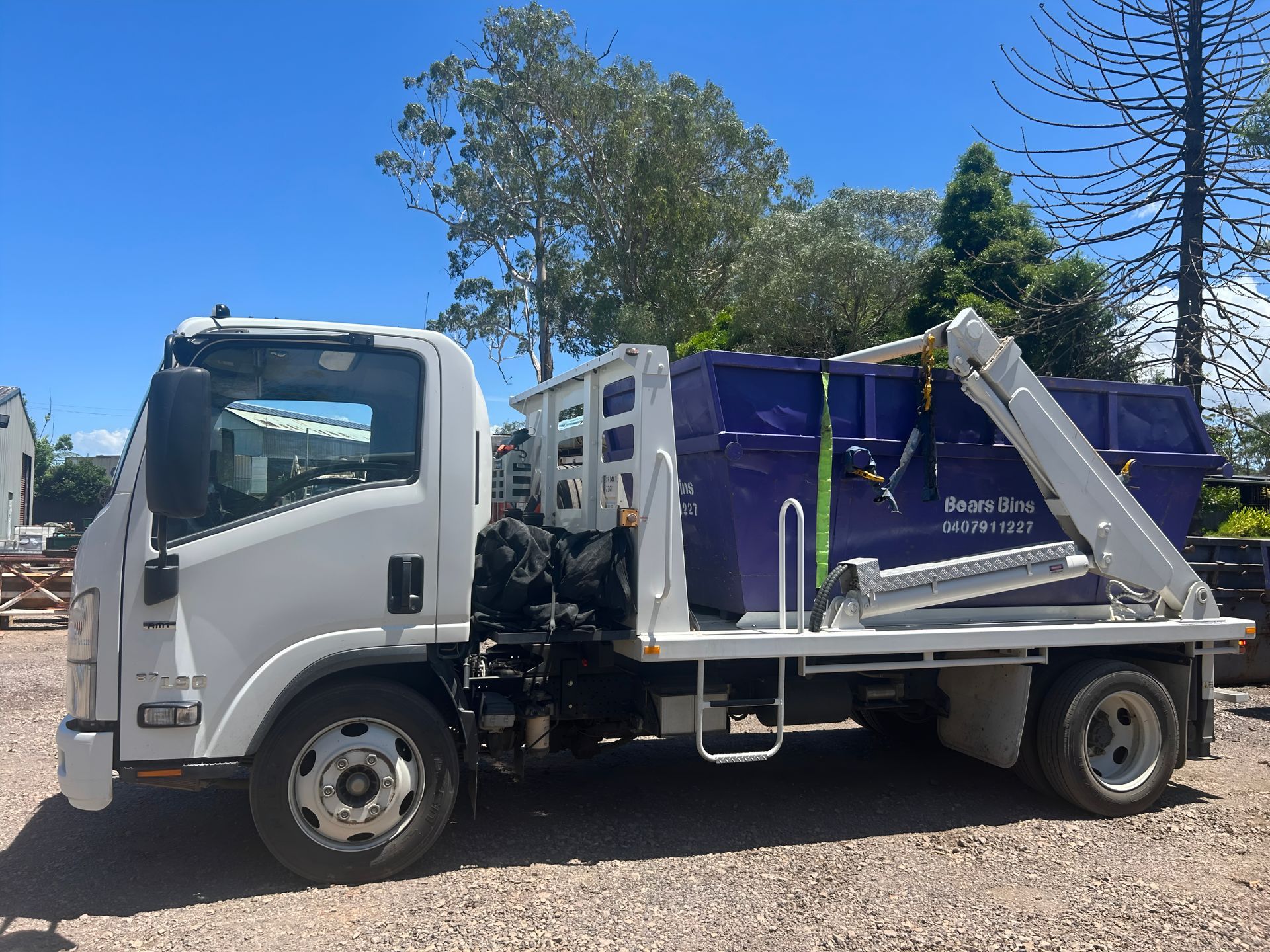 White Truck With a Blue Dumpster on a Sunny Day — Skip Bin Hire Sunshine Coast in Kin Kin, QLD