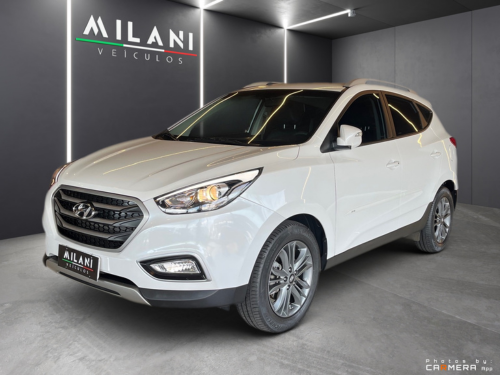 Biele SUV Hyundai vystavené v showroome s nástenným označením značky.