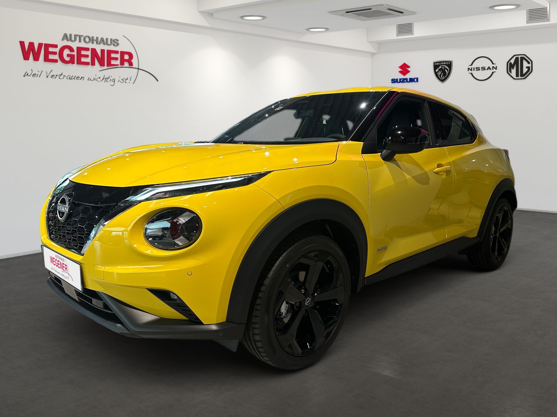 Gelber Kompakt-SUV im Ausstellungsraum, schräge Frontansicht mit schwarzen Felgen und schwarzem Dach.