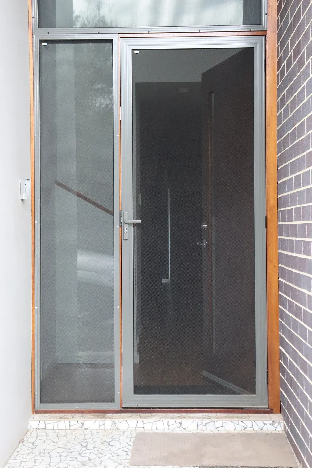 A sliding glass door with a brick wall behind it
