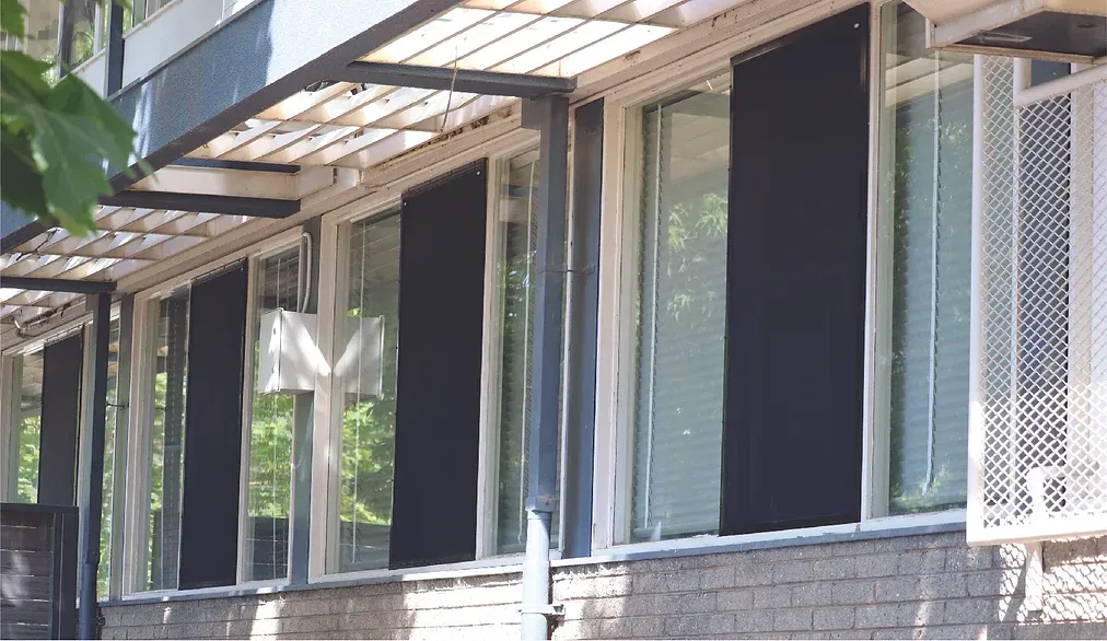 A building with a lot of windows and black blinds