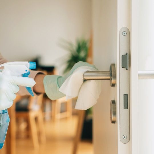 A person is cleaning a door handle with a cloth