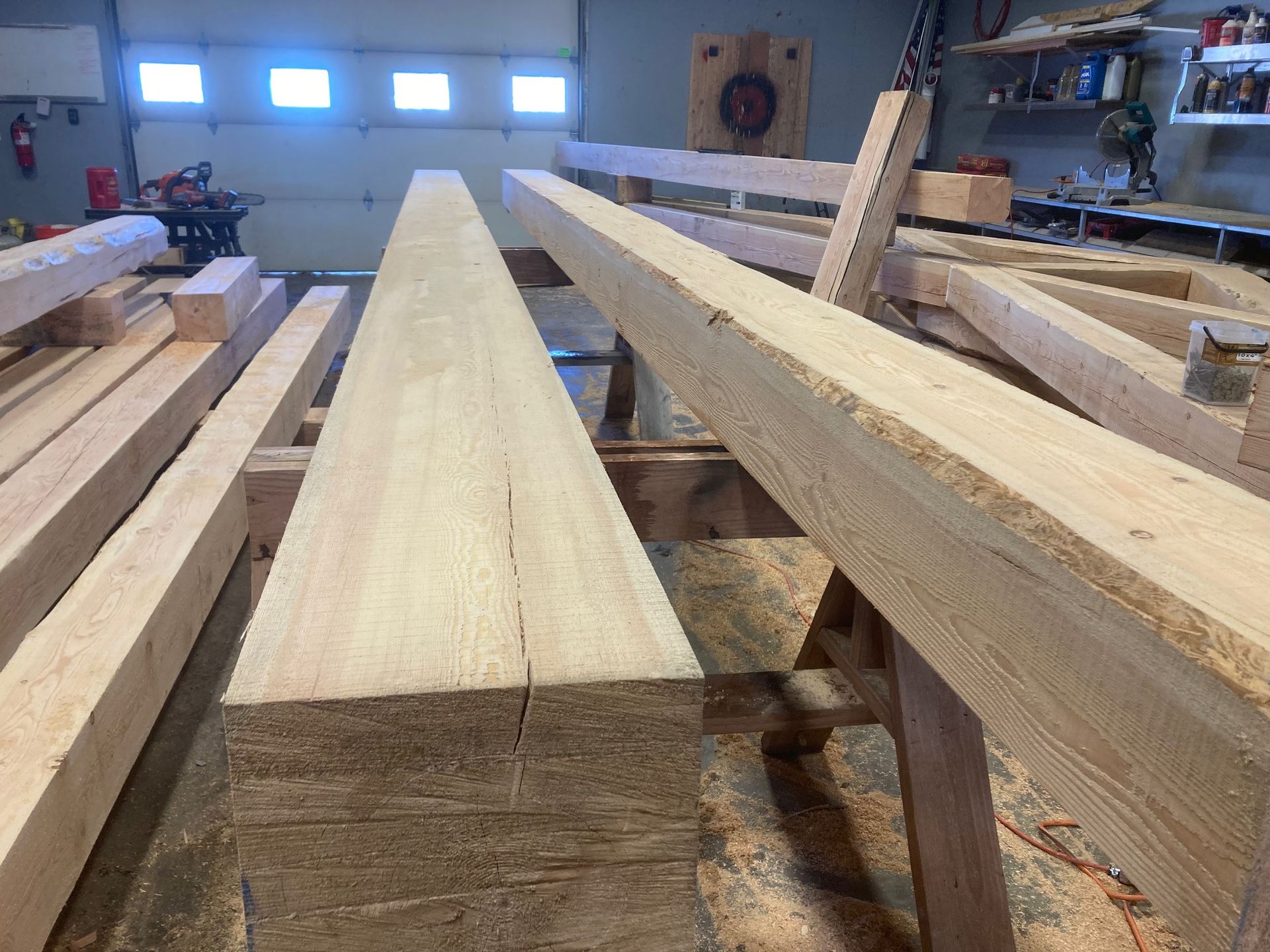 A bunch of wooden beams are stacked on top of each other in a garage.