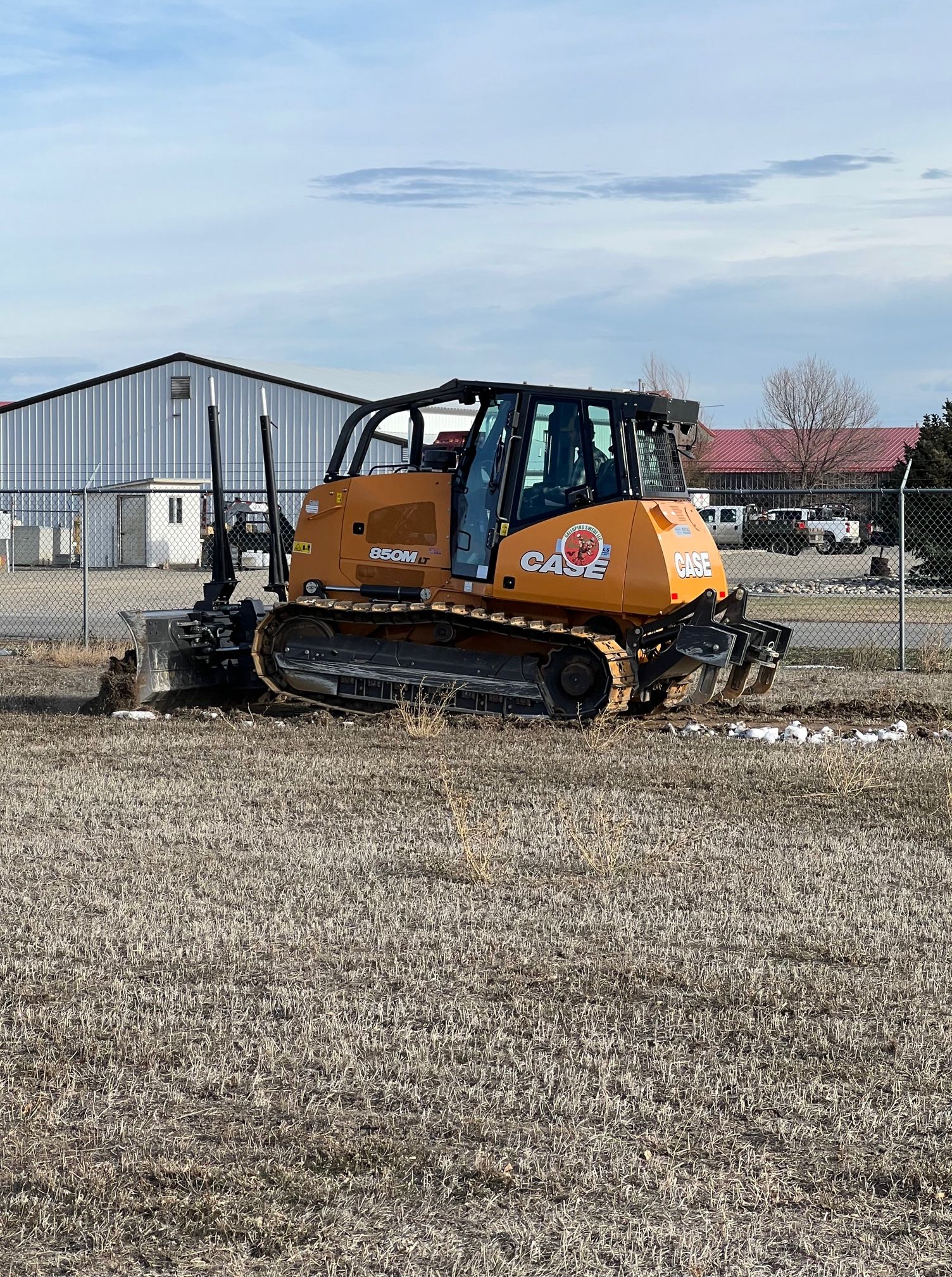 A bulldozer is sitting in the middle of a dirt field.