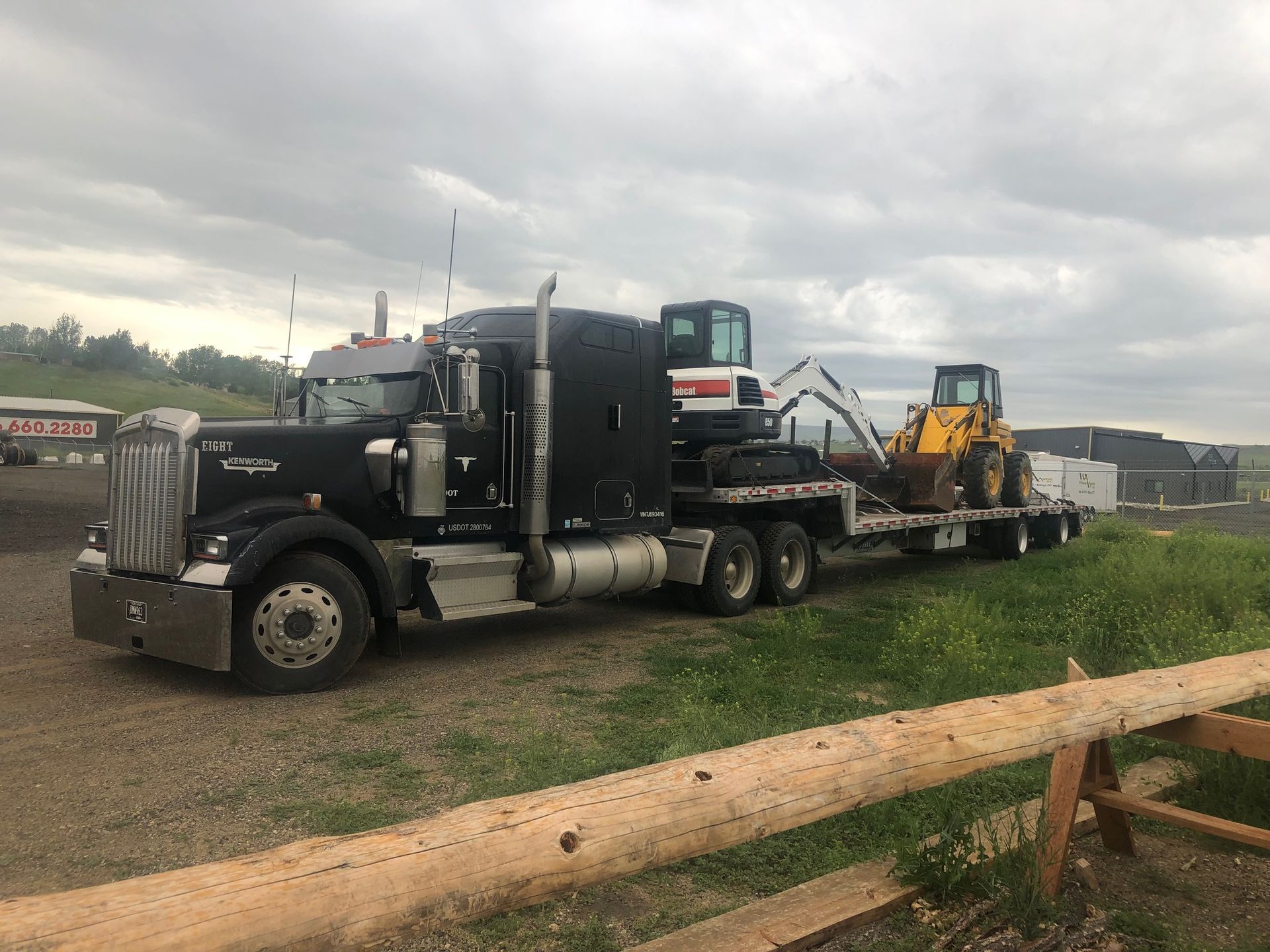 A semi truck is carrying a bulldozer on a flatbed trailer.