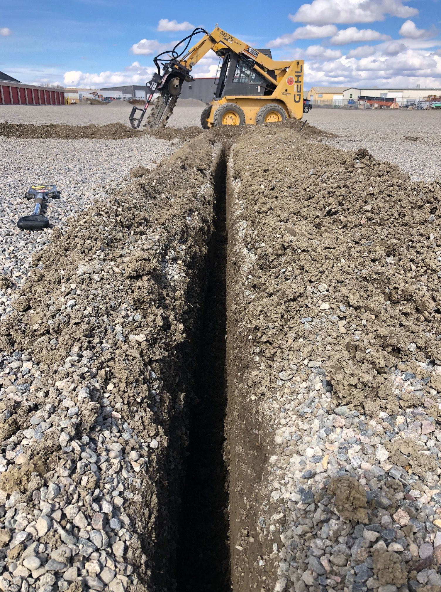 A bulldozer is digging a trench in the dirt.