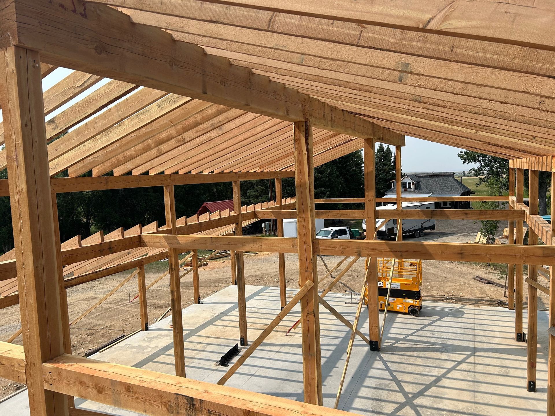 A large wooden structure is being built on a dirt field.
