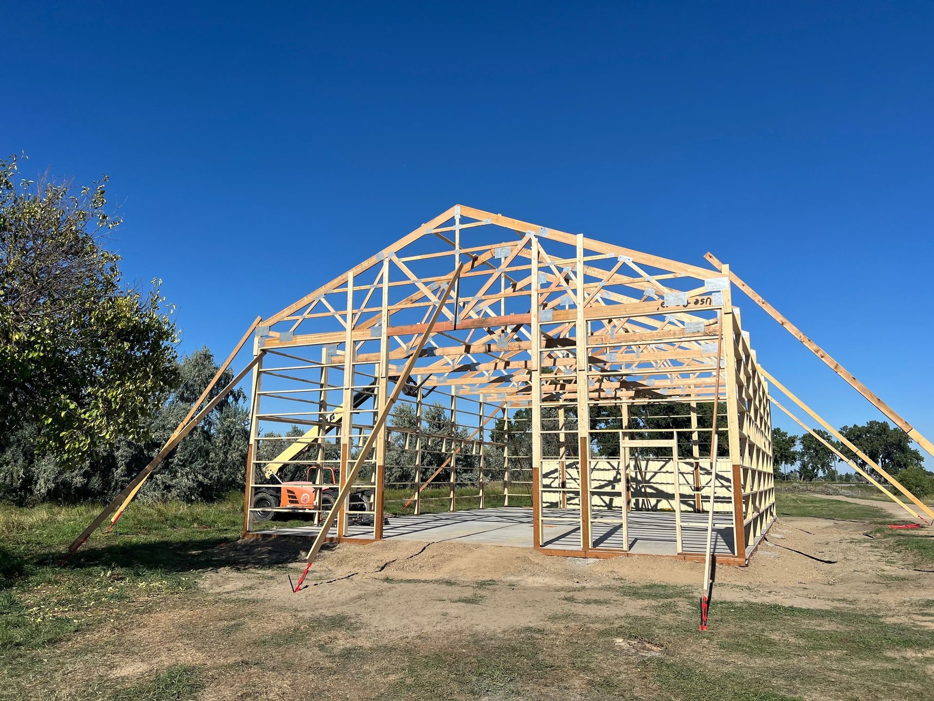 A large wooden structure is being built in a field.
