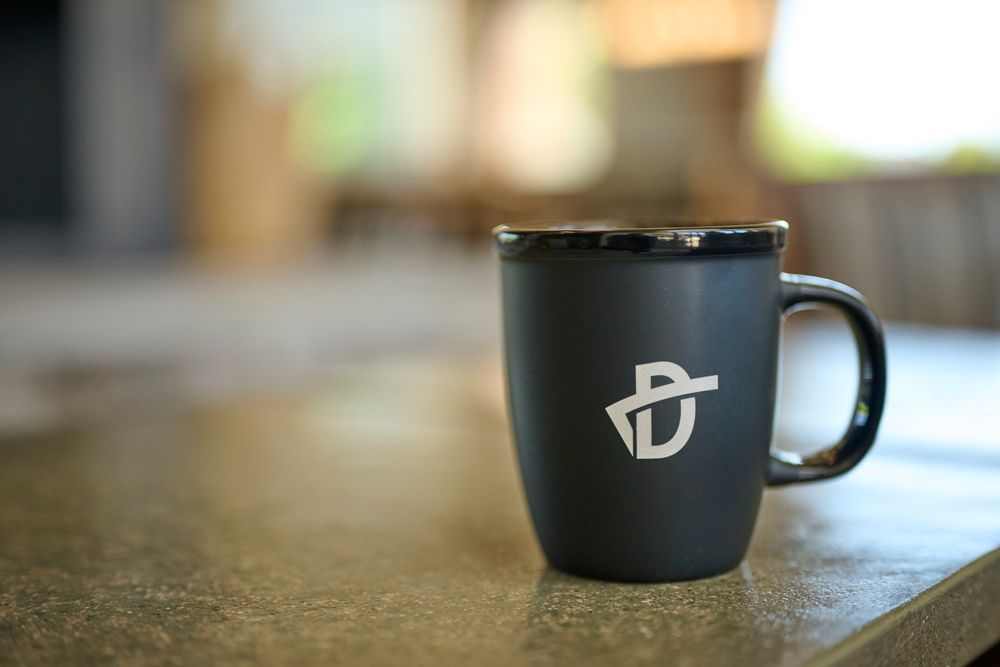 Black coffee mug with white logo — The District at Parkcenter